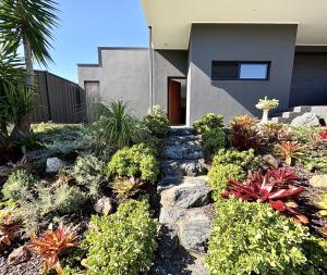 a garden with plants in front of a house at Korora's Haven Coffs Harbour in Kororo Basin +10 photos