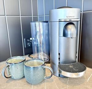 a coffee maker and two cups on a counter at Korora's Haven Coffs Harbour in Kororo Basin