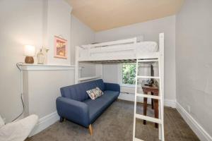 a bedroom with a blue chair and a bunk bed at Chic Vintage Vibes Stylish Stay Near It All in Spokane