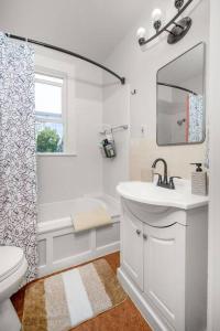 a bathroom with a sink and a toilet and a mirror at Chic Vintage Vibes Stylish Stay Near It All in Spokane +50 photos