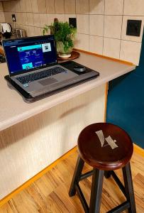 a laptop computer sitting on a counter with a chair at Modern retro private apartment in Polokwane +1 photo