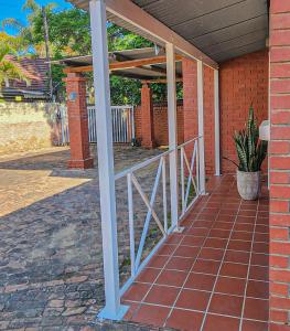 a porch of a house with a metal railing at Modern retro private apartment in Polokwane