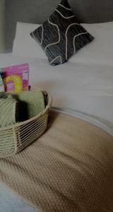 a basket of towels and a pillow on a bed at Modern retro private apartment in Polokwane