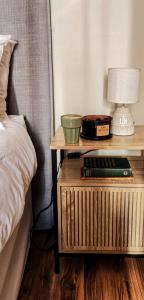 a bedside table with a lamp and a night stand with a bed at Modern retro private apartment in Polokwane