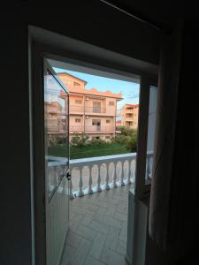 a door to a balcony with a view of a building at Infinity room in Velipojë