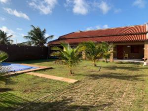 a house with a yard with palm trees in front of it at Casa de praia - Trairí CE in Trairi