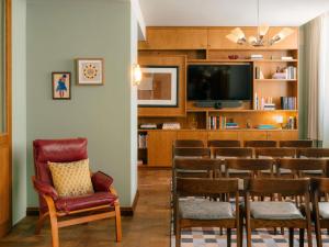 a room with a bar with chairs and a tv at The Hoxton Vienna in Vienna