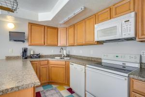 a kitchen with wooden cabinets and white appliances at Easy AFB Commute! Clearfield Unit w/ Private Patio in Clearfield