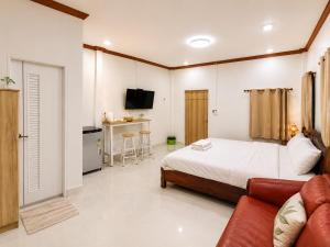 a bedroom with a bed and a couch and a kitchen at DD HOMESTAy หาดสะพลี in Ban Tha Samet (1)