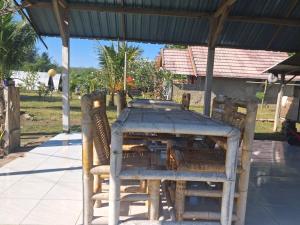 a wooden table and chairs under a roof at Dinoyin Bungalows in Gili Meno +40 photos