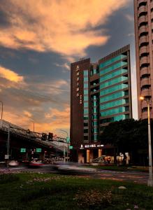 a tall building with a bridge in front of it at K Hotel Taipei Dunnan in Taipei
