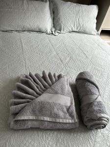 a blanket is laying on a bed at Maggi Residence in Batatais