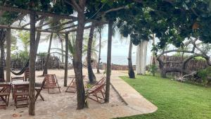 a patio with a table and chairs and the ocean at Casa Monan Atins Beach in Barreirinhas