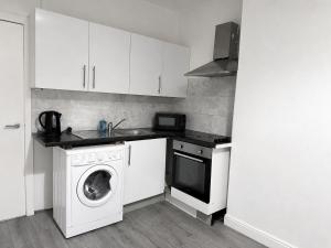 a kitchen with a washing machine and a dishwasher at Private Flat Near City Centre in Peterborough +5 photos