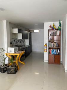 a kitchen with a table and a book shelf at Tunja Magic Habitación in Tunja