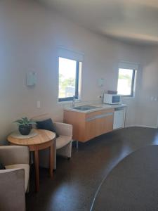 a kitchen with a couch and a table and a sink at Headlands Hotel in Opunake