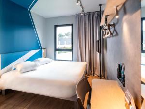 a hotel room with a bed and a window at ibis budget Morlaix in Morlaix