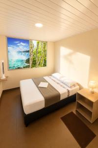 a bedroom with a large bed and a window at Hotel Arboleda de Cádiz in Ibagué