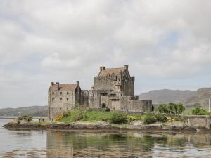 an old castle on an island in the water at Craggan Cottage - Balmacara in Coillemore +17 photos