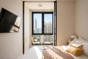 a bedroom with a bed and a large window at Urbanstay Seomyeon in Busan