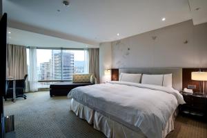 a hotel room with a large bed and a desk at K Hotel Taipei Dunnan in Taipei +70 photos