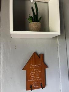 a wooden arrow sign on a wall with a plant at Casa proximo parque in Santa Rosa +2 photos