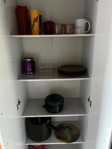 a white shelf with plates and cups and pans at Casa proximo parque in Santa Rosa