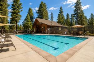 a swimming pool with a house and trees at Lariat House in Sisters