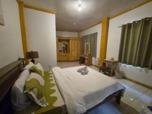 a bedroom with a large white bed in a room at Danao RM House in Idanao