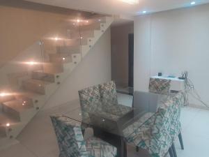 a dining room with a table and chairs and a staircase at Guimarães in Viçosa