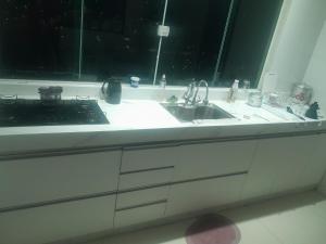 a kitchen counter with a sink and a stove at Guimarães in Viçosa