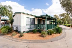 a small house with a green and white at Riverside Cabin Park in Shepparton