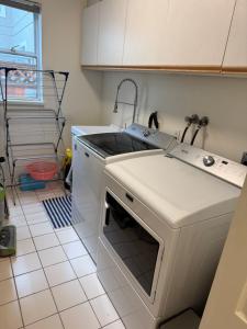 a kitchen with a sink and a stove at As You Wish Suites & Rooms Near YVR with Parking in Richmond