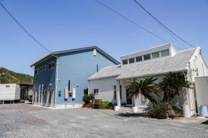 a large blue building next to a white house at Sea Breeze 1987 in Nagato