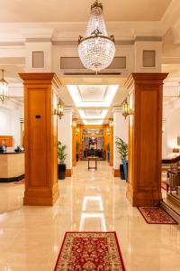 a lobby with a chandelier and a hallway with columns at Castlereagh Boutique Hotel, an Ascend Collection Hotel in Sydney