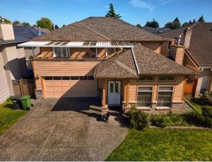 a house with a roof with a garage at As You Wish Suites & Rooms Near YVR with Parking in Richmond
