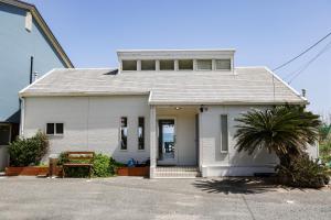 a white house with a tree in front of it at Sea Breeze 1987 in Nagato