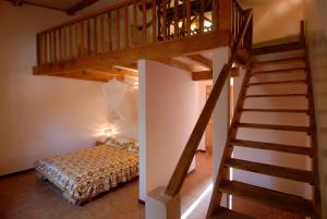 Un escalier mène à une chambre en mezzanine avec un lit. dans l'établissement Hotel Cap Saint Louis, à Saint-Louis