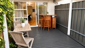 a patio with chairs and a table on a deck at Verandah Suite in Seacliff