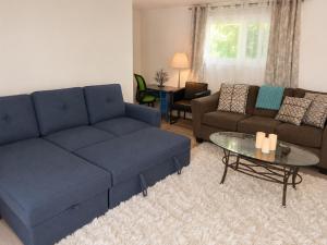 a living room with a blue couch and a table at Lagoon Views Near Bird Sanctuary in Victoria