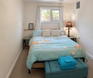 a bedroom with a bed with a blue comforter and a window at Lagoon Views Near Bird Sanctuary in Victoria