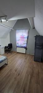 a room with a large screen in a room with a wooden floor at Belle chambre 2 in Seraing
