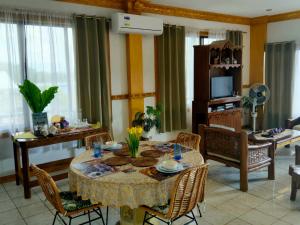 a living room with a table with chairs and a television at Danao RM House in Idanao