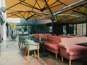 a restaurant with couches and tables and chairs at ibis Styles Lisboa Aeroporto in Lisbon