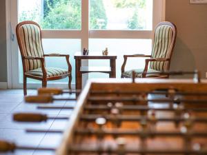 two chairs and a table in front of a window at greet Hôtel Montbéliard in Montbéliard