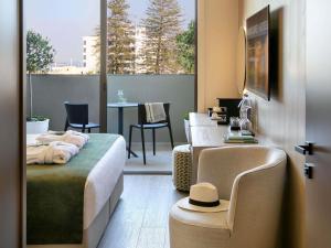a bedroom with a bed and a table with a hat on it at Mercure Larnaca Finikoudes Beach in Larnaca +101 photos