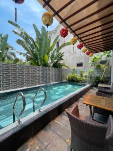 a swimming pool with a table and chairs next to it at Laughter Garden villas in Tân Thành (1)