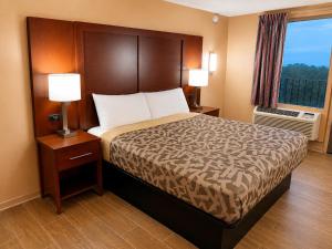 a hotel room with a bed with two lamps and a window at Overlook Mountain Inn in Guntersville +2 photos