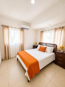 a bedroom with a bed with an orange blanket at Modern Villa 2 BR Near Airport, Beaches, Dining in Punta Cana +21 photos