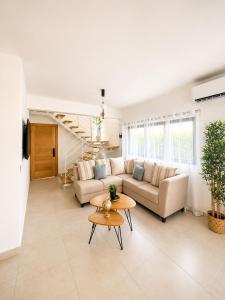 a living room with a couch and a table at Modern Villa 2 BR Near Airport, Beaches, Dining in Punta Cana